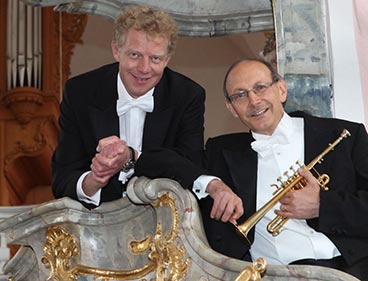 Foto Bernhard Kratzer mit Trompete und Paul Theis vor der Orgel auf einer barocken Kirchenballustrade